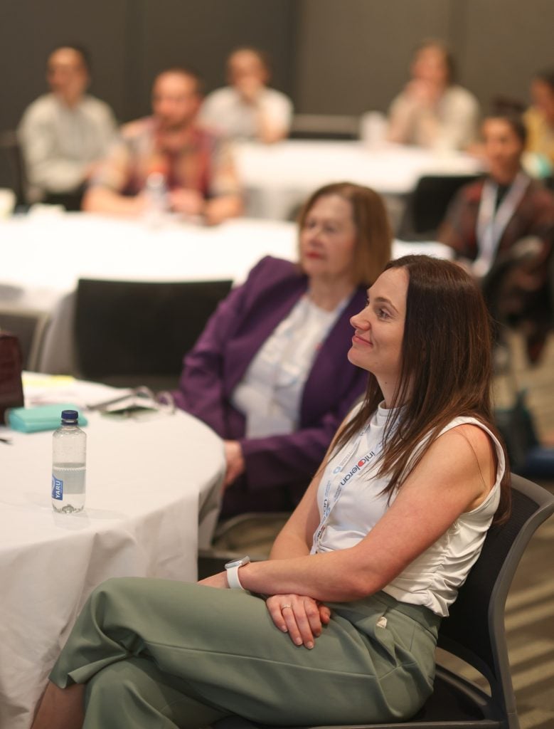 Delegates seated at round tables during a 2024 conference workshop